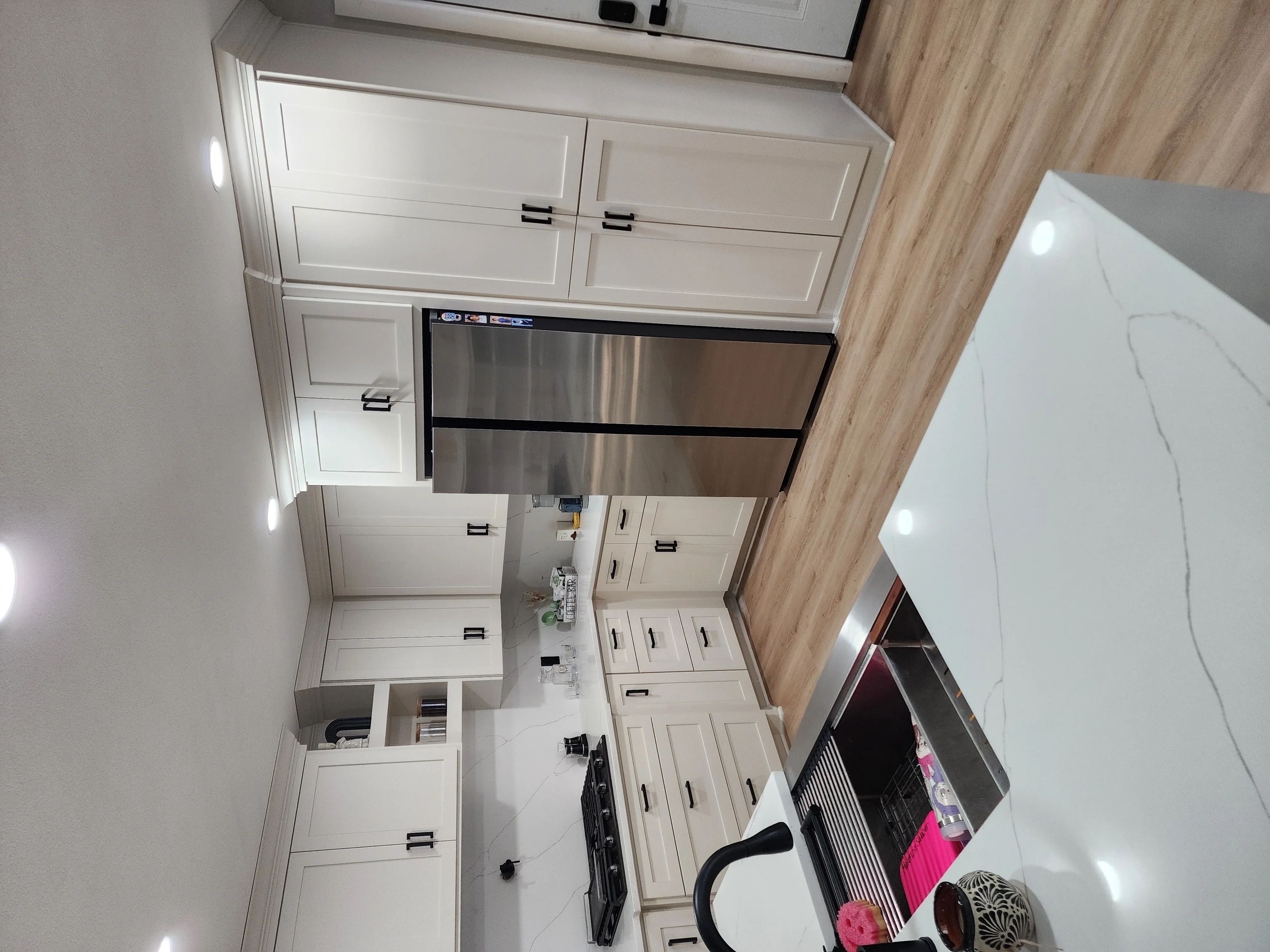 White shaker cabinets with stainless steel range hood and appliances in modern kitchen